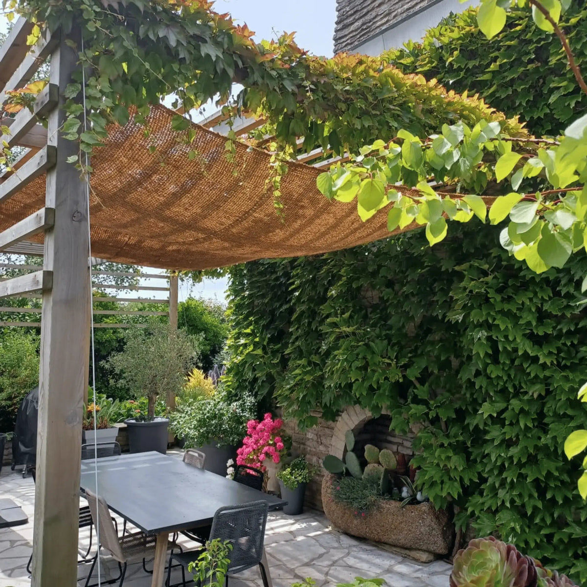 Kokos schaduwdoek boven een tuintafel met klimplant