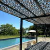 Versterkt grijs camouflagenet boven een pergola naast het zwembad
